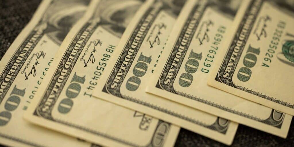 a pile of twenty dollar bills laying on top of each other